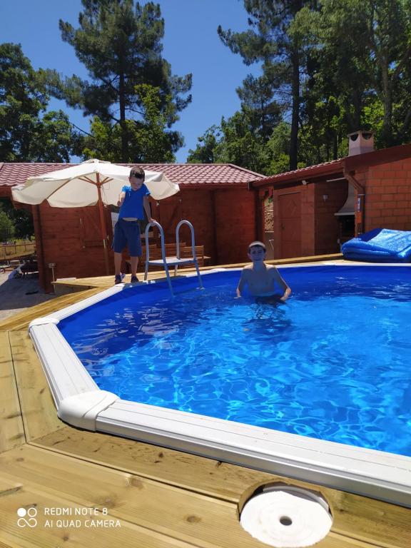 比索达雷加Casa das Vinhas Velhas by Casa do Poço的两个人站在游泳池里