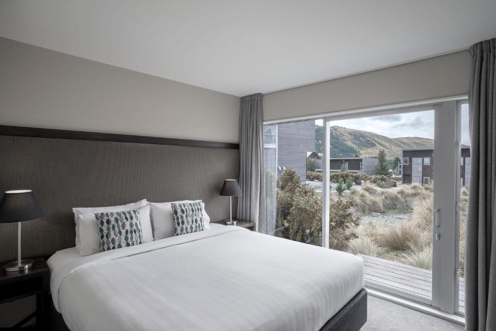 特卡波湖湖蓝水度假村的一间卧室设有一张大床和一个大窗户