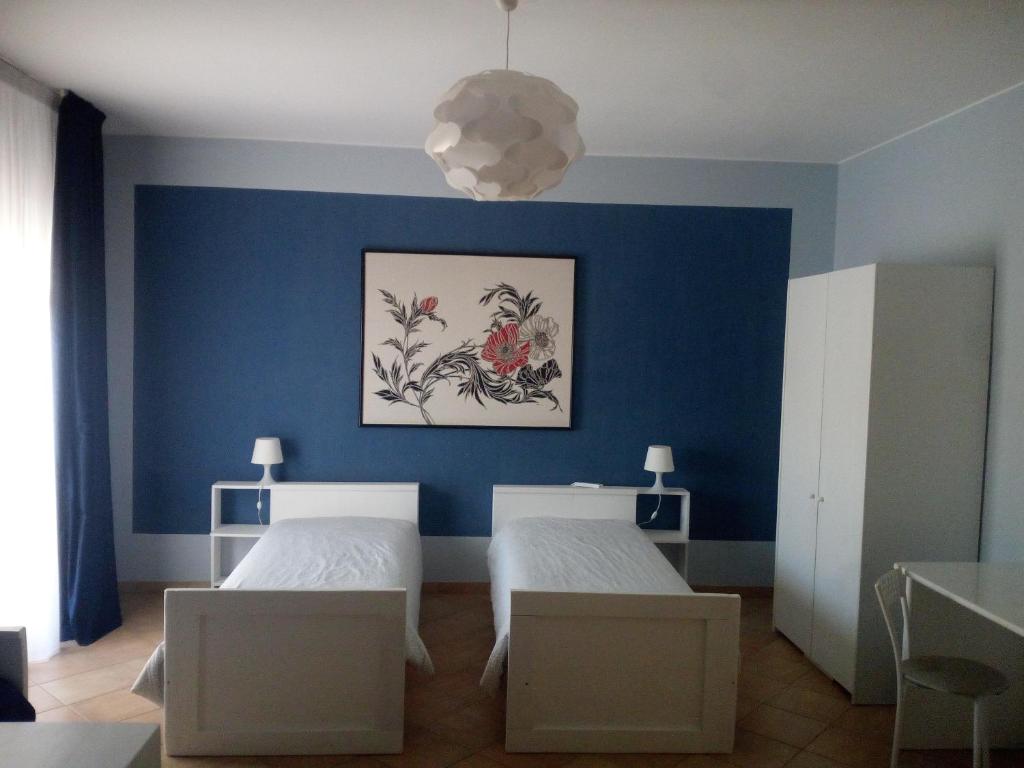 圣埃拉莫因科莱The holiday house的一间卧室设有两张床和蓝色的墙壁