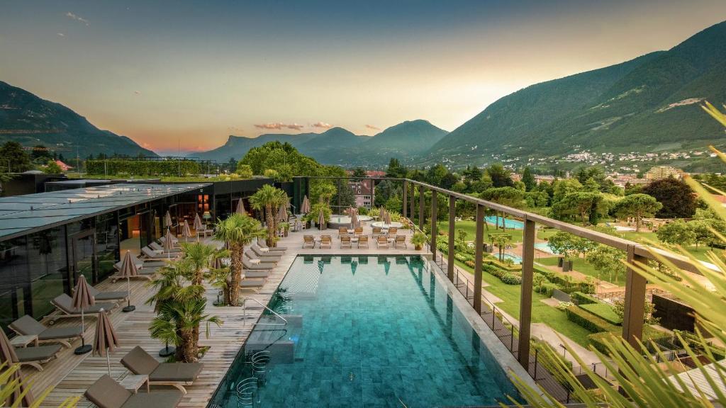 梅拉诺梅拉温泉酒店 - 梅拉诺温泉的背景为游泳池和山脉的酒店