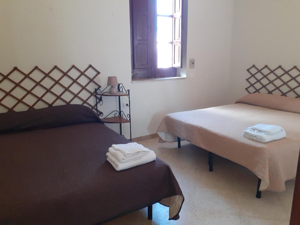 法维尼亚纳Faraglioni house的一间设有两张床的房间,配有毛巾