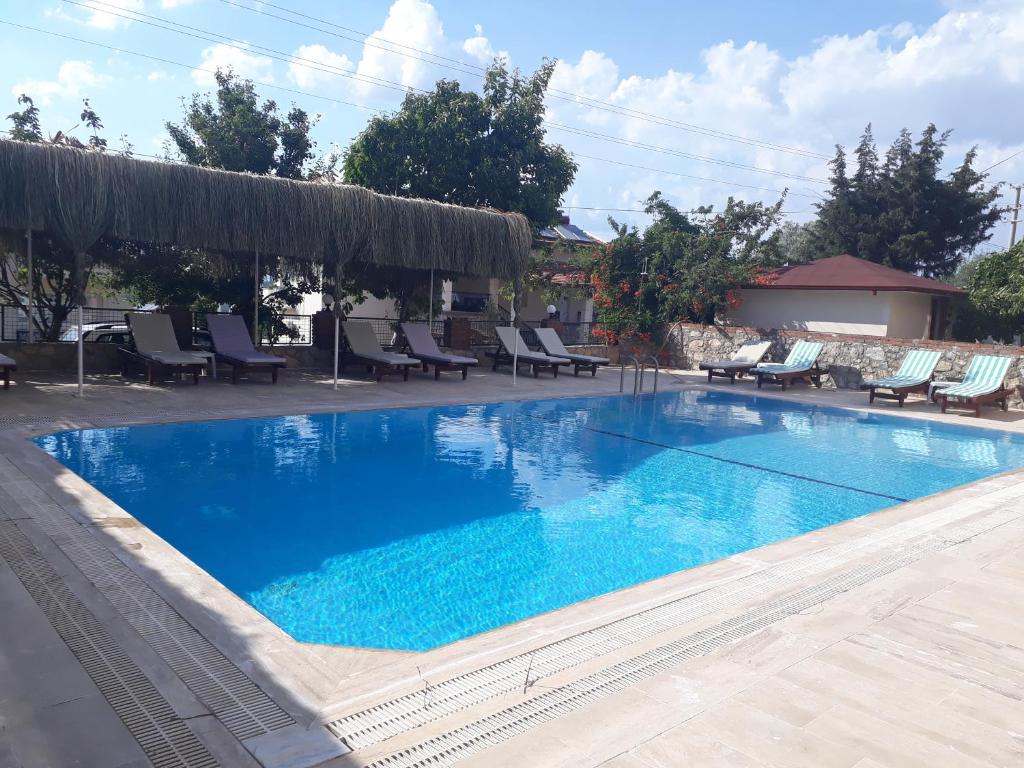 厄吕代尼兹Hotel NilSu的一座蓝色海水大型游泳池,配有躺椅