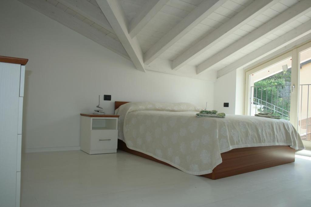 拉韦诺appartamenti i fiori del lago的白色的卧室设有床和窗户