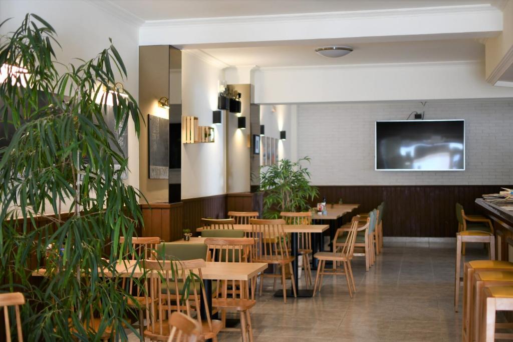 圣安东尼奥马洛卡旅馆的餐厅设有木桌、椅子和平面电视。