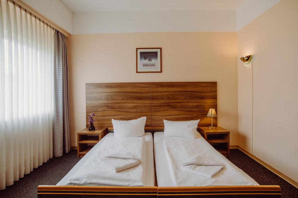 柏林阿尔珀上午波茨坦广场酒店的一间卧室设有两张床和木制床头板