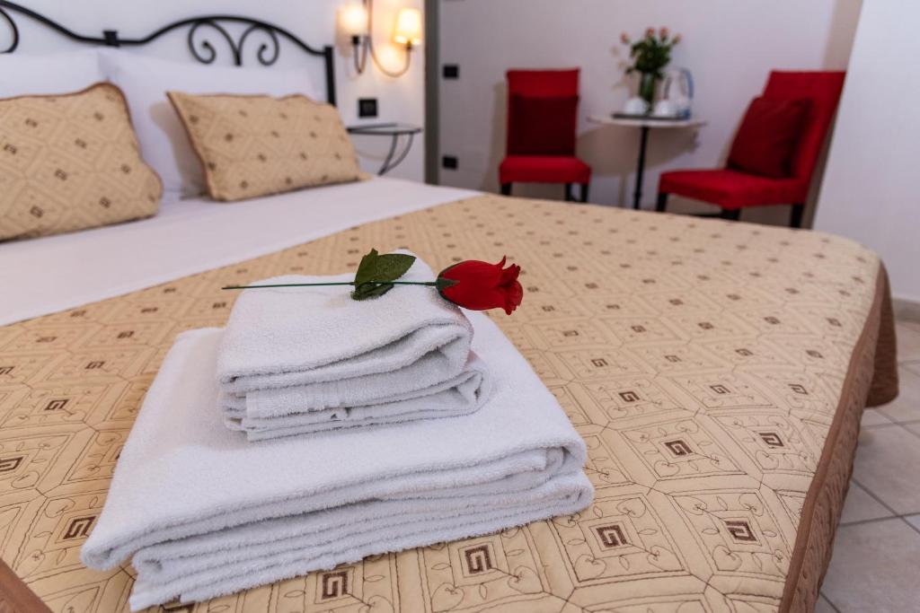 佛罗伦萨Dei Mori - Guest House的床上的一大堆毛巾,上面有一朵花