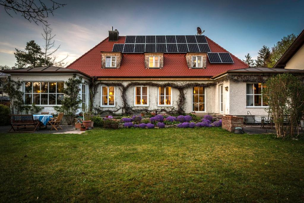 普拉赫München- Pullach, Wohnen im Grünen的屋顶上设有太阳能电池板的房子