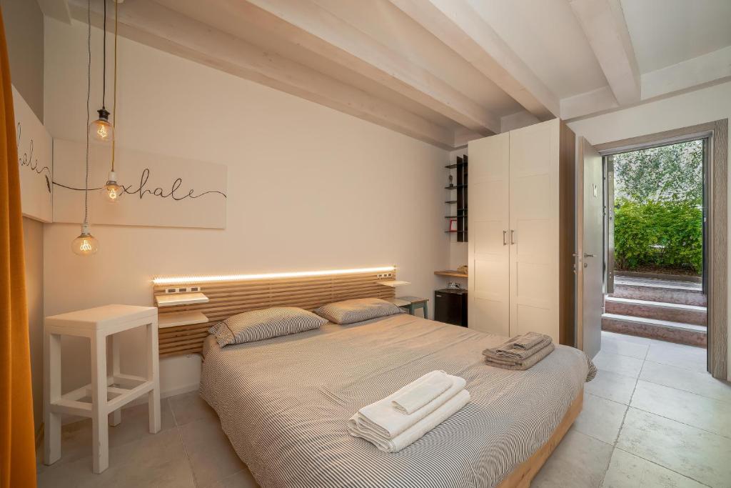 阿科Le Scuderie B&B的一间卧室配有一张大床和两条毛巾