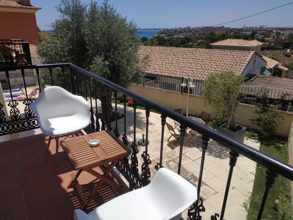 坎佩略Apartamento vistas al mar - Coveta Fuma的阳台配有2把白色椅子和桌子