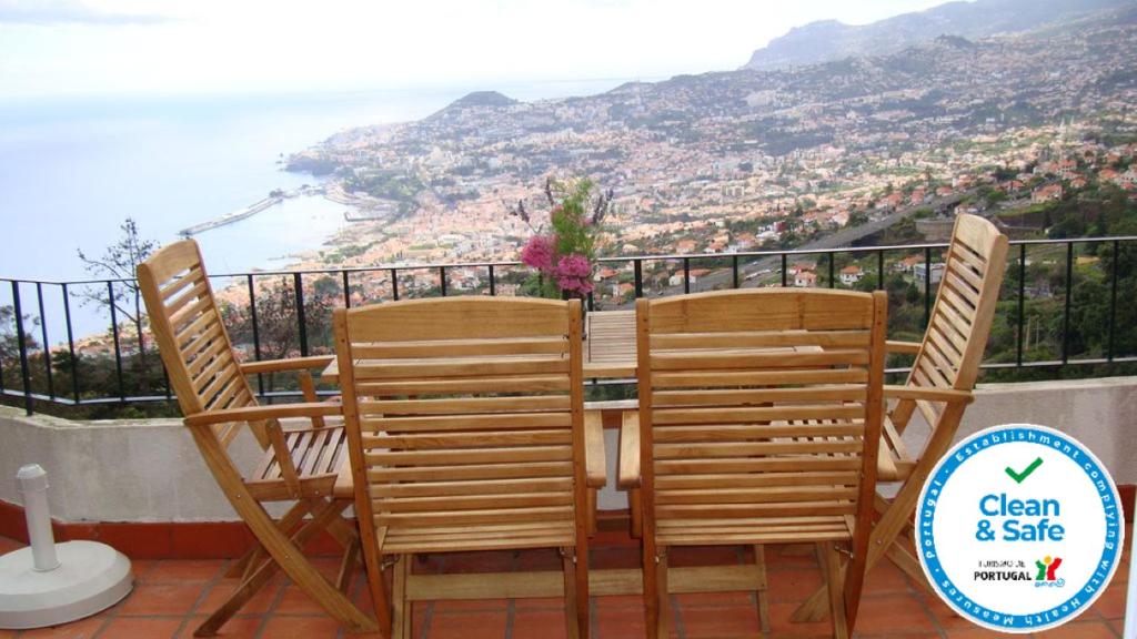 丰沙尔Apartamento Charmoso no Funchal, com grande Jardim e Vista Esplêndida的一张桌子和椅子,享有海景