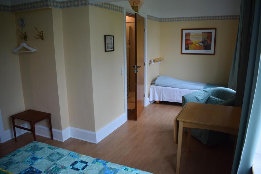 斯泰厄亚伽姆勒斯经济型酒店（客房&早餐）的小房间设有一张床、一张桌子和一张桌子