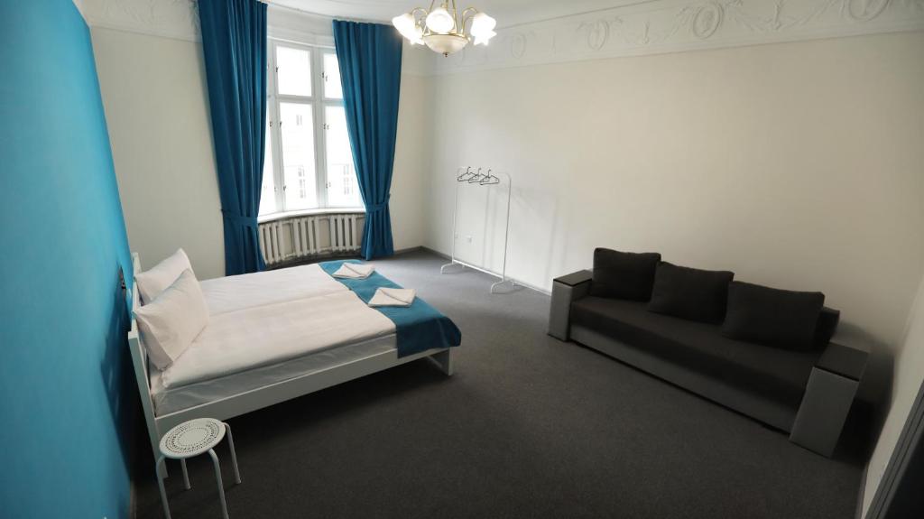 利沃夫Family Hostel Lviv的一间带床和沙发的小卧室