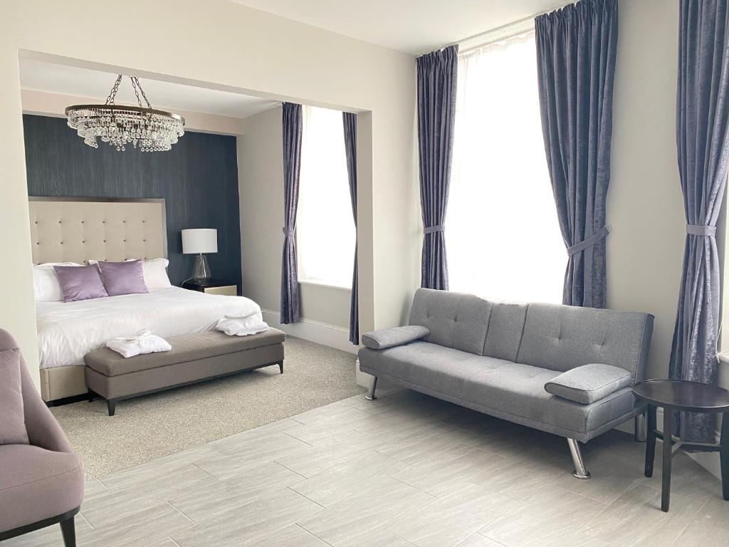 滨海克拉克顿The Royal Hotel - Clacton On Sea的一间卧室配有一张床、一张沙发和一把椅子