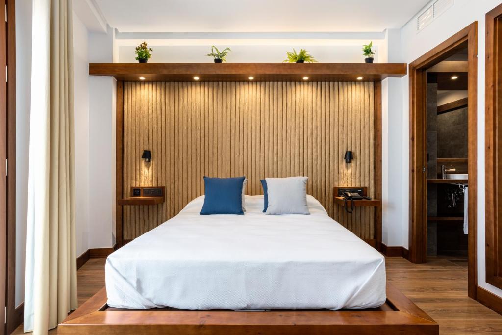 科尼尔-德拉弗龙特拉Hotel Antantie的卧室配有带蓝色枕头的大型白色床