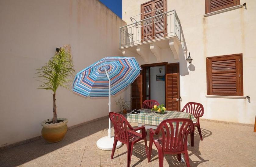 圣维托罗卡波Casa Sarina的庭院里配有桌椅和遮阳伞