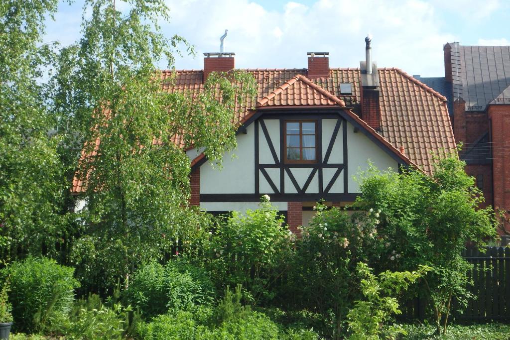 兹姆巴克U Aptekarzy的一座带瓷砖屋顶和树木的房子