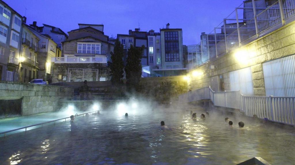 奥伦塞Polvorín的一群人晚上在喷泉里游泳