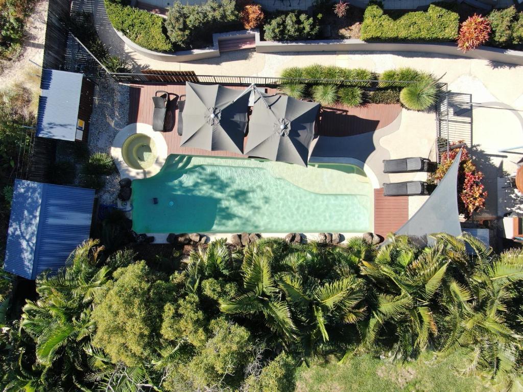 拜伦湾拜伦湾海滨小屋公寓式酒店的享有度假村的空中景致,设有游泳池和棕榈树