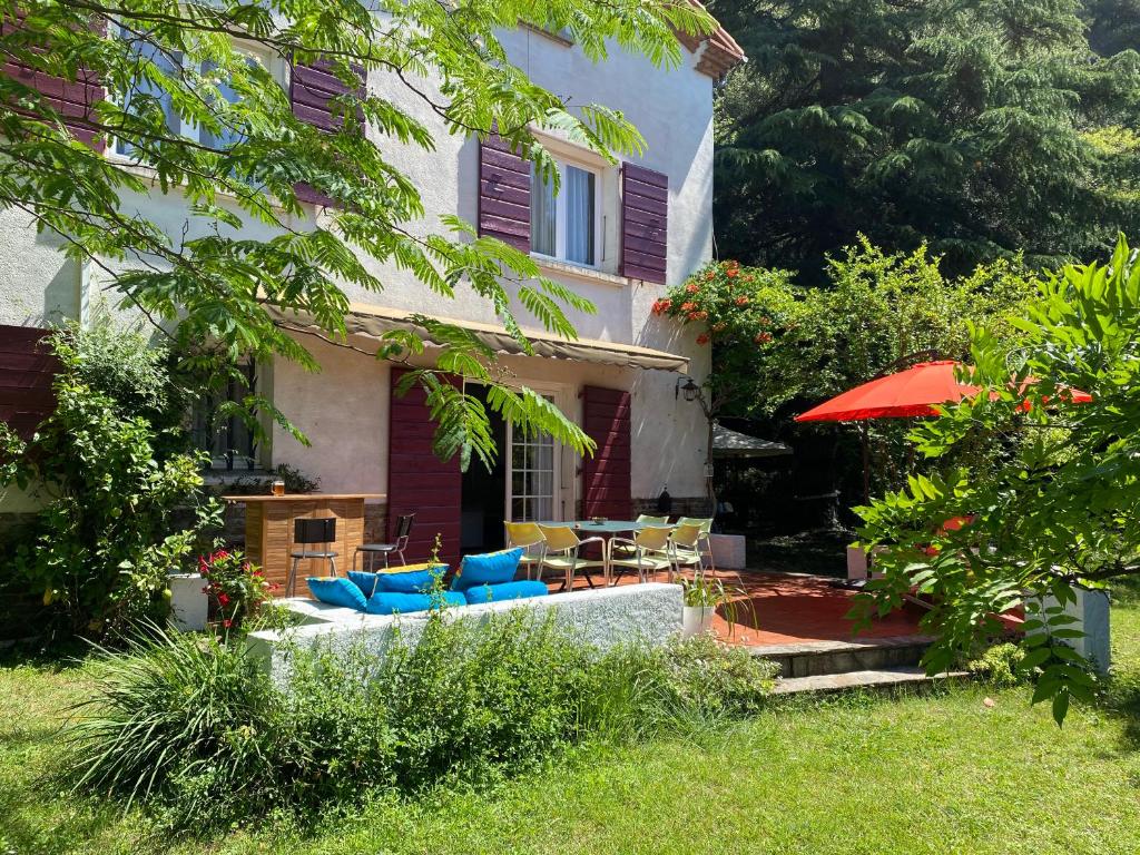 阿梅利莱班帕拉勒达Villa Riviera Chambres Privées的房屋设有庭院、椅子和遮阳伞