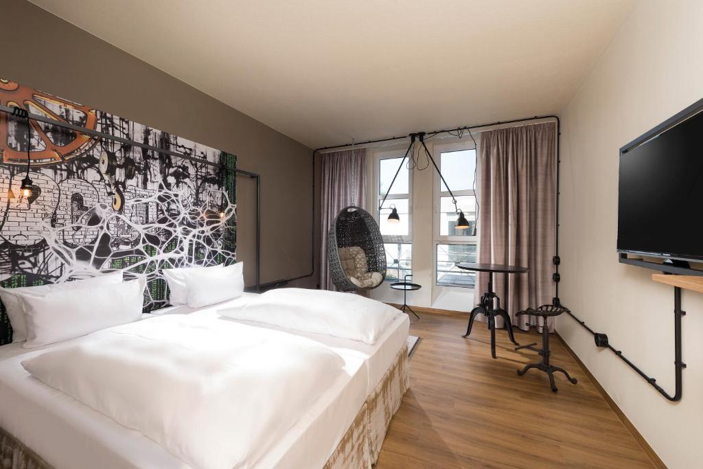 纽伦堡Seminaris Hotel Nürnberg的卧室配有一张白色大床和电视。