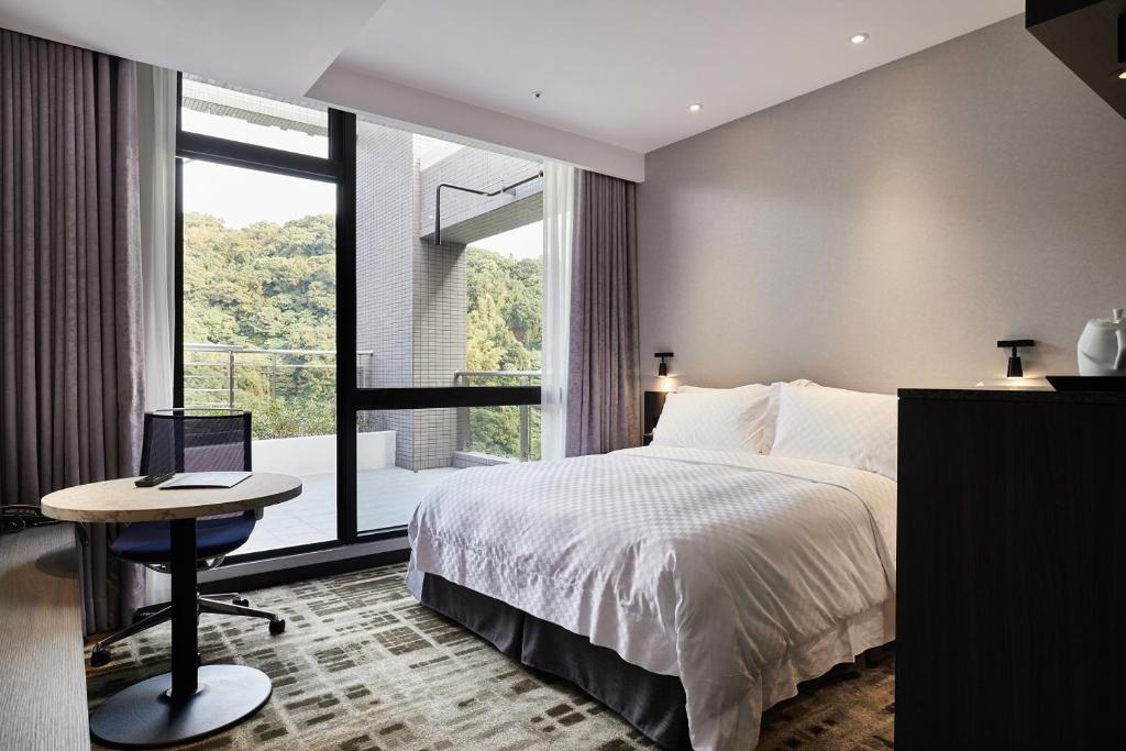 台北天阁酒店台北士林的一间卧室配有一张床和一张带笔记本电脑的桌子