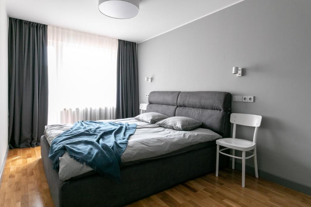 文茨皮尔斯Brand New, Family-friendly with a great location - Moon Apartment的一间卧室配有一张带椅子的床和一扇窗户