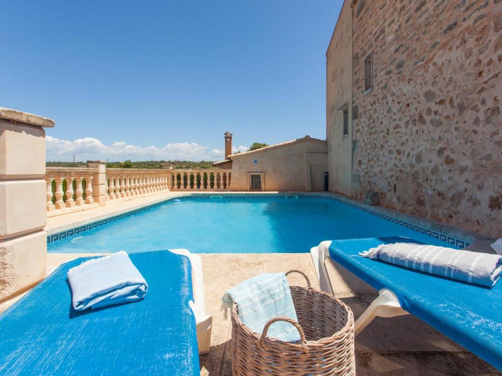塞萨利内斯Na frare casa de campo的一个带蓝色桌子和椅子的大型游泳池