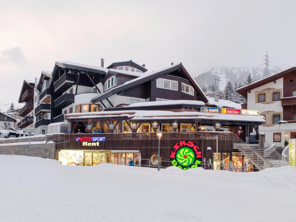 圣安东阿尔贝格Quality Hosts Arlberg - Hotel Bergheim的雪地里的一座建筑,上面有标志