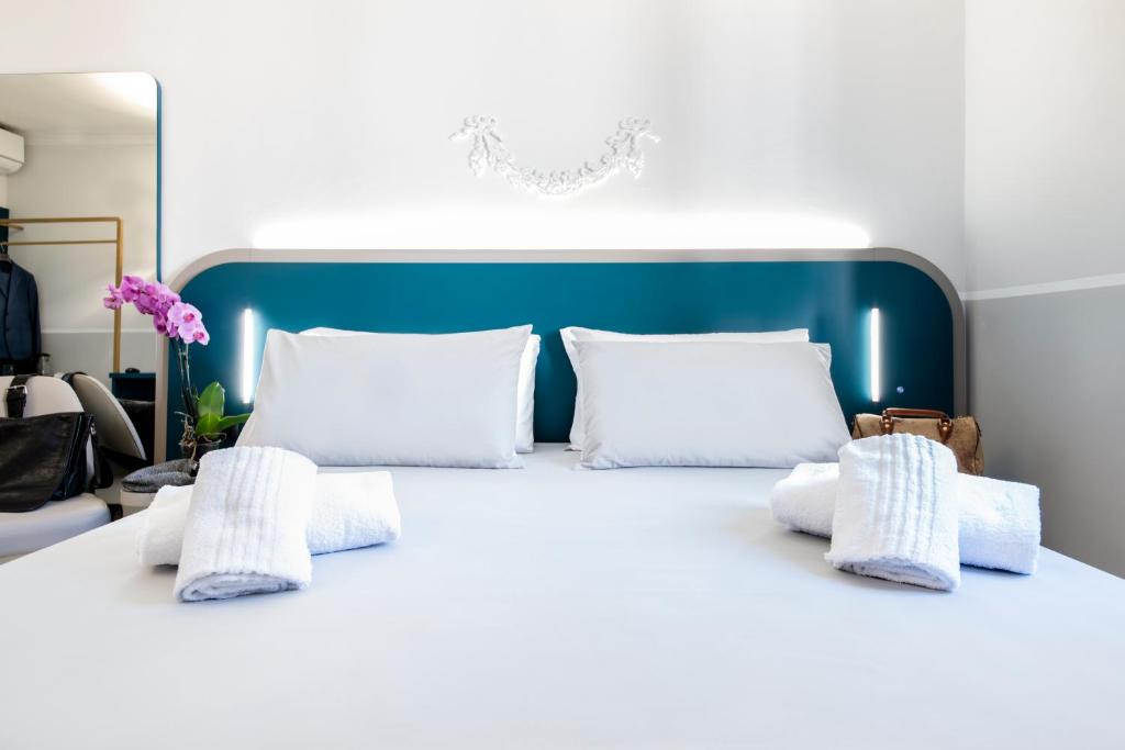 罗马德里佛酒店的白色的床、白色枕头和蓝色床头板