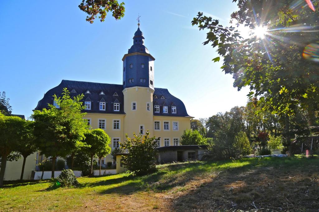 博恩海姆瓦伦堡古堡酒店的山顶上一座带钟楼建筑
