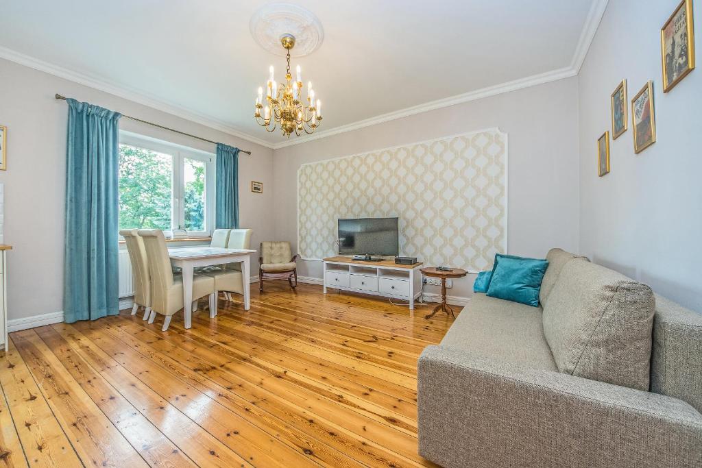 索波特Victus Apartamenty, Apartament Dębowa的客厅配有沙发和桌子