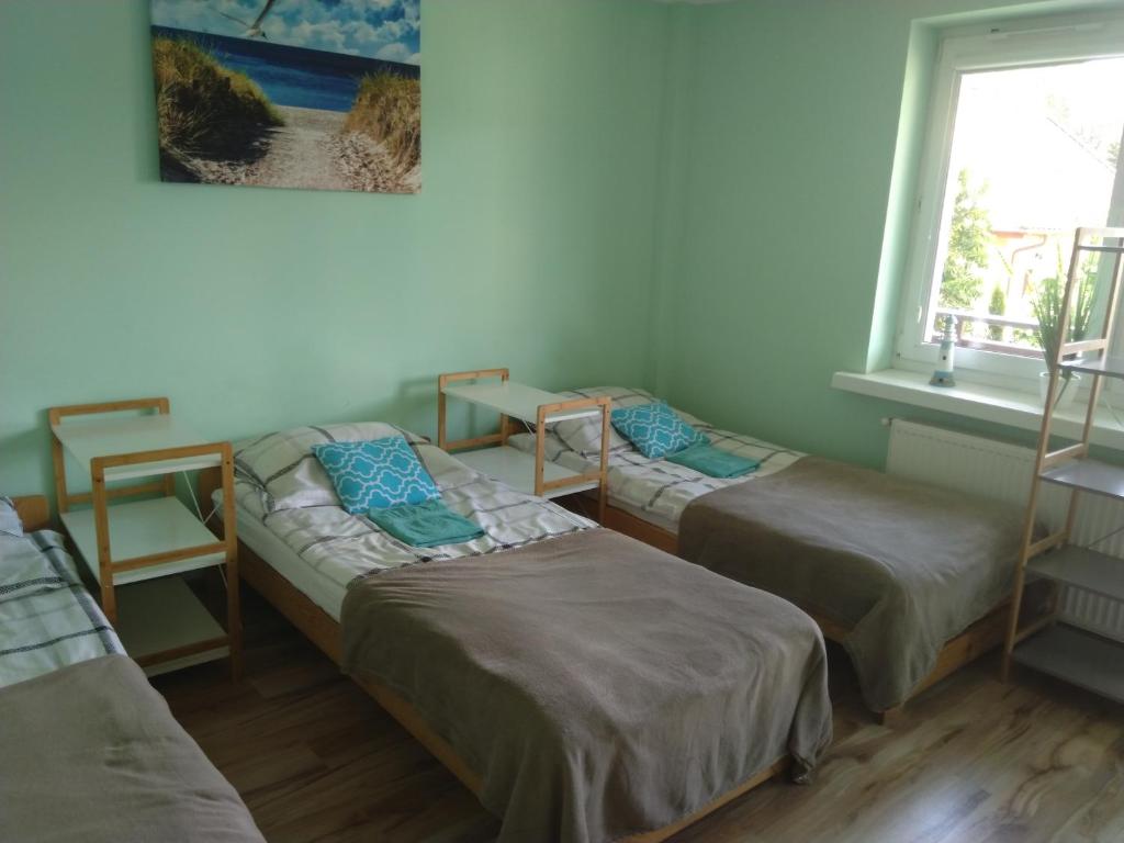露米雅Pokoje Gościnne Bajka的带三张床和窗户的客房