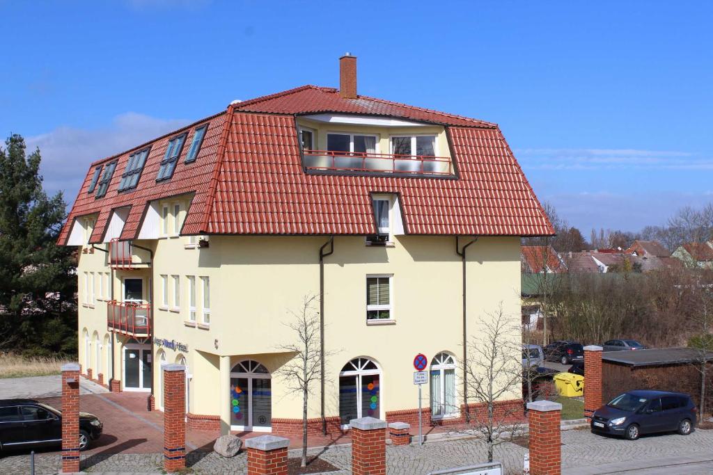 乌埃克尔明德Ferienwohnung am Schloss的一座白色的大建筑,有红色的屋顶