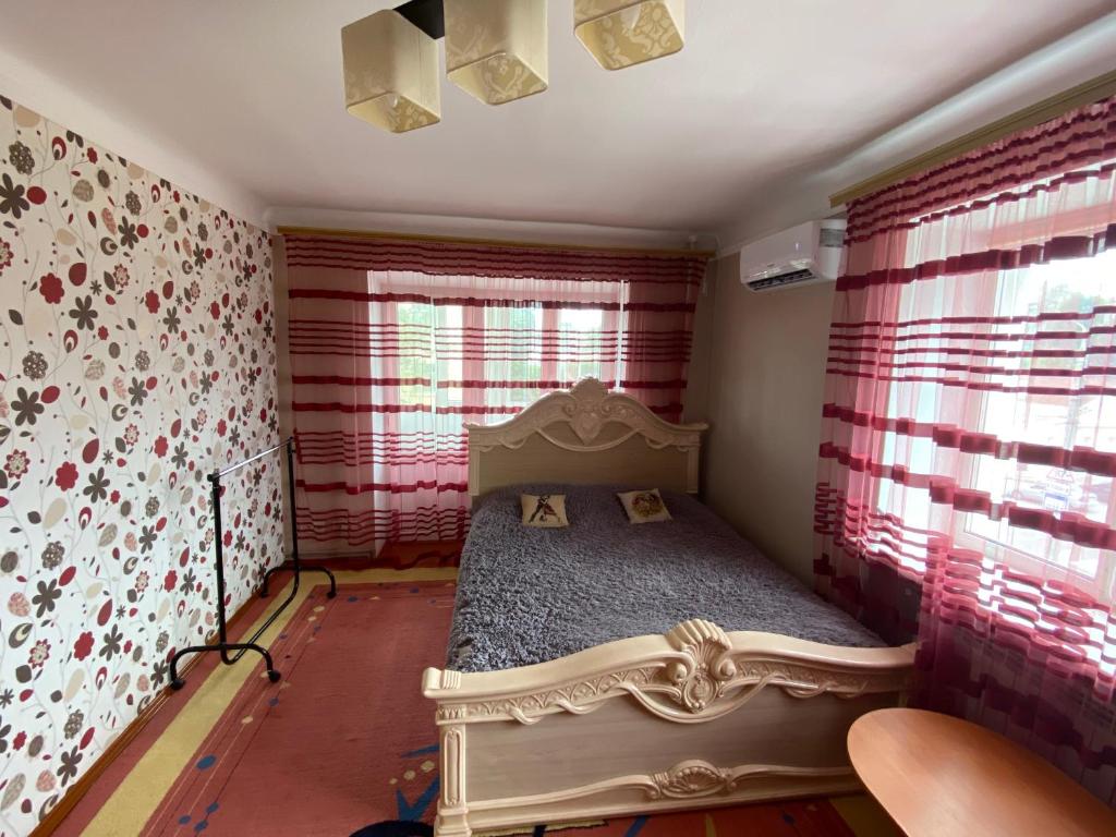 日托米尔Михайлівська квартира的一间设有床铺的卧室,位于一个红色墙壁的房间