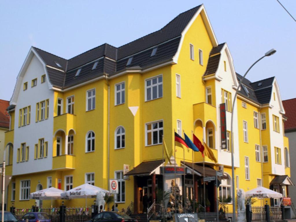 柏林卡尔舒斯特酒店的黑色屋顶的大型黄色建筑