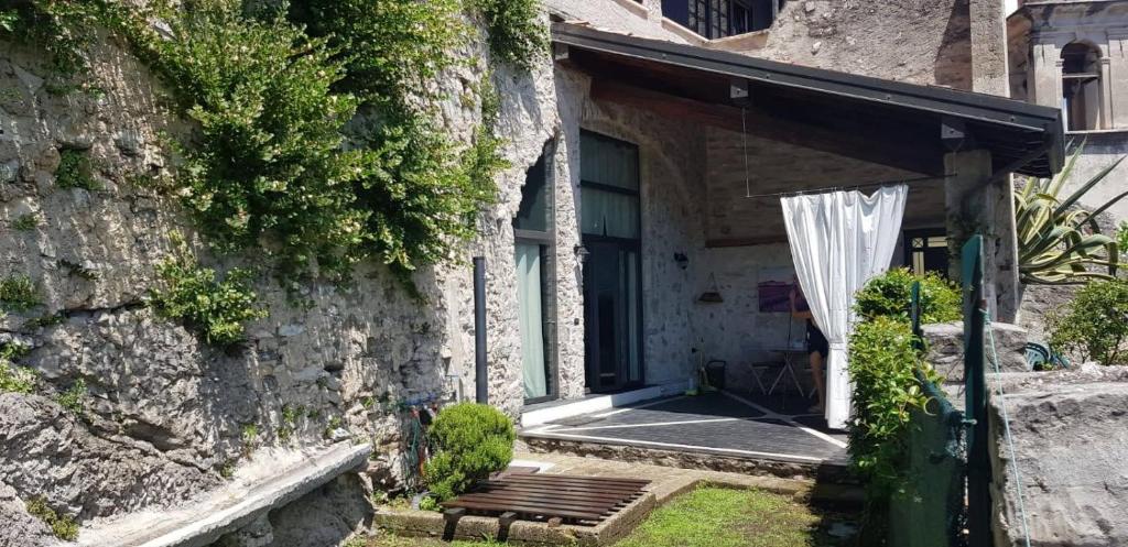 利莫内-苏尔加达Casa Limonaia San Rocco的石头房子,带长凳和遮阳伞