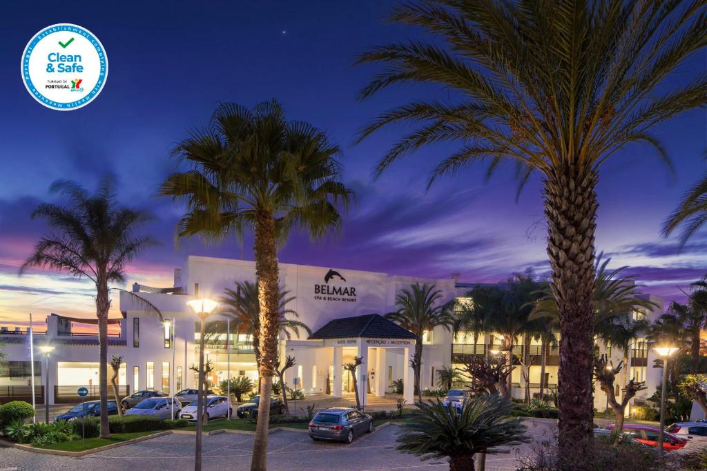 拉戈斯贝勒马Spa及海滩度假酒店的一座楼前有棕榈树的酒店
