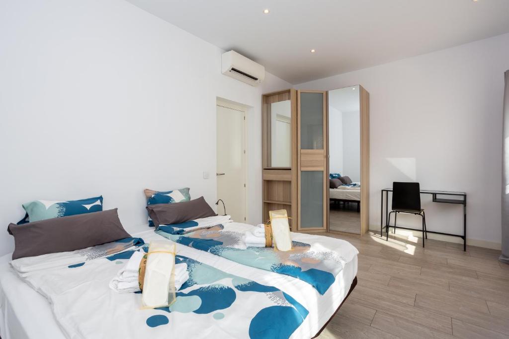 马德里阿尔玛套房公寓的一间卧室配有一张带蓝白色床单的大床