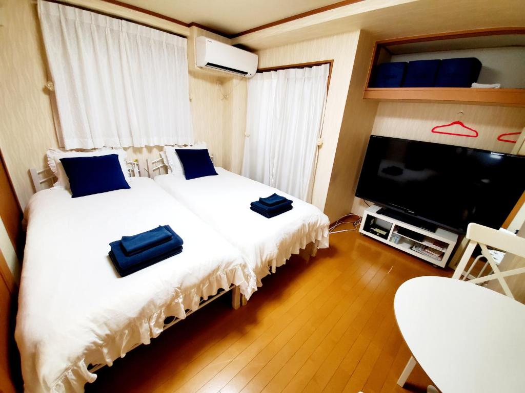 神户Takaraboshi room 101 Sannomiya10min的一间卧室配有一张床和一台平面电视