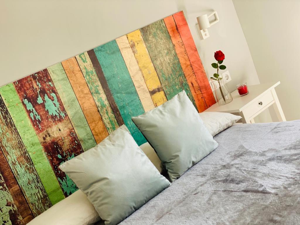 加的斯Atico Loft The Rose 48的一张带两个枕头的床和彩色的墙壁