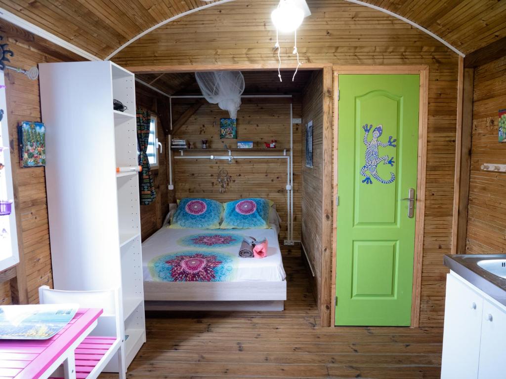 勒穆莱La Roulotte De Tina的小房间,设有床和绿门