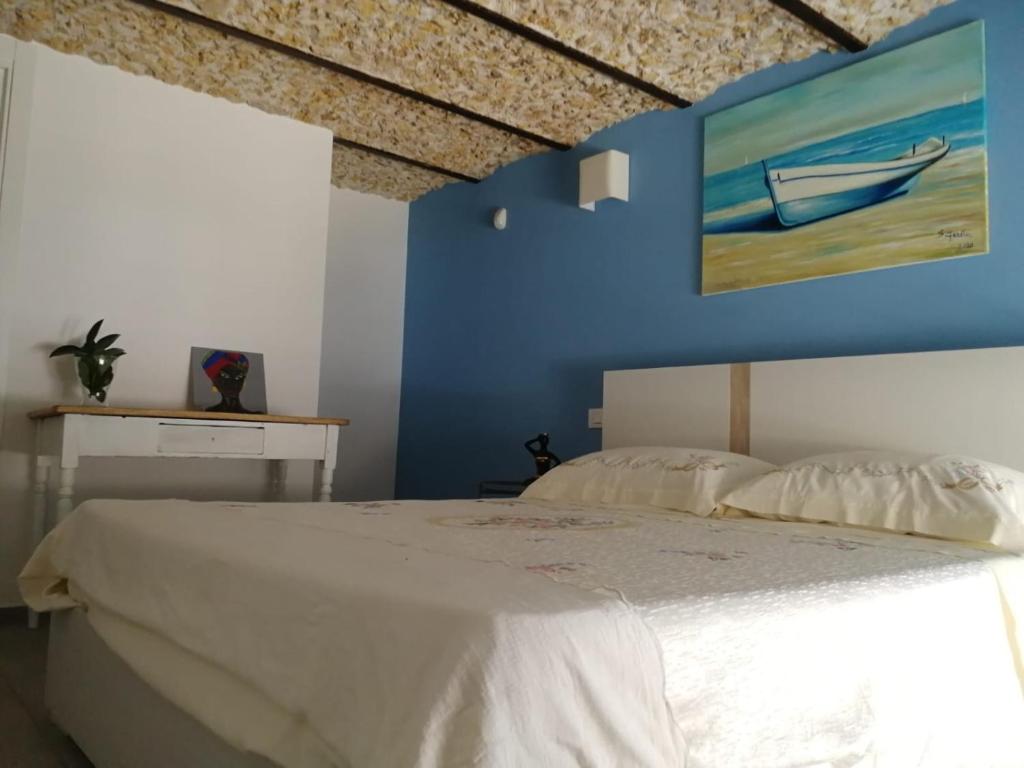 锡拉库扎A casa di Ninuccia的卧室配有白色的床和蓝色的墙壁