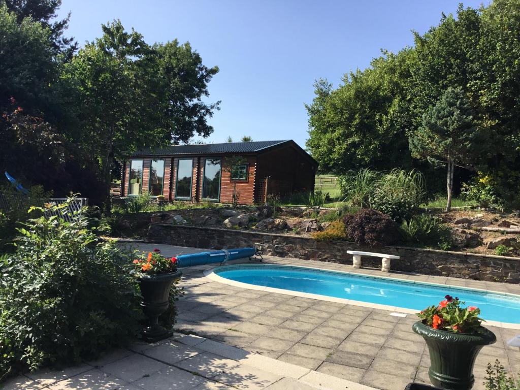 利斯卡德Tudor Lodge的花园内的游泳池,带房子