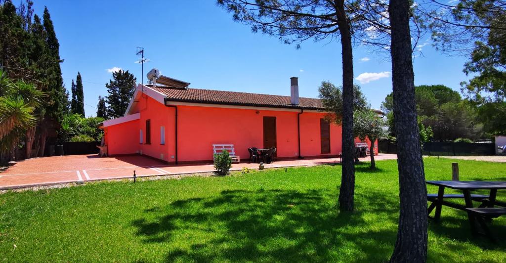 阿尔盖罗Casa RoSi的公园里一座红色的建筑,设有野餐桌
