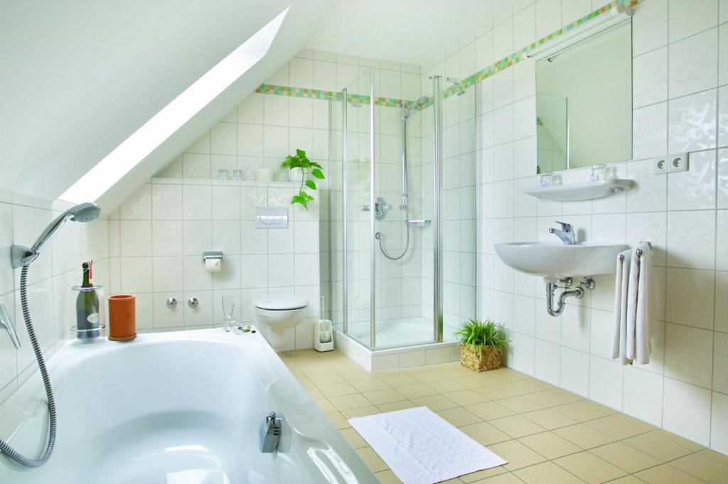 航旺兰德加斯特霍夫&怀尔特兰德酒店的带浴缸、盥洗盆和卫生间的浴室