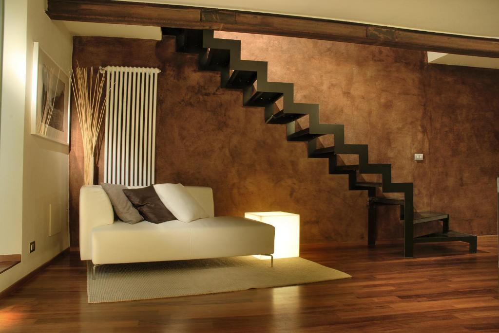 都灵特莱斯奇遇套房住宿加早餐旅馆的客厅设有白色沙发和楼梯。