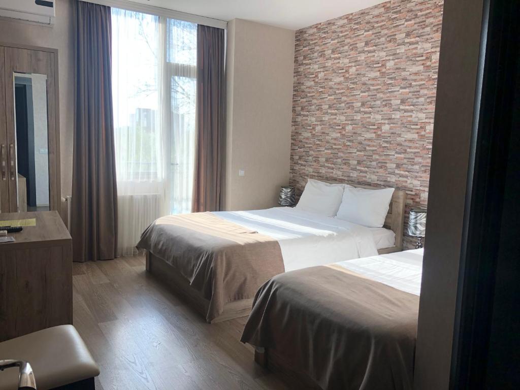 库塔伊西洲际大酒店的酒店客房带两张床和砖墙
