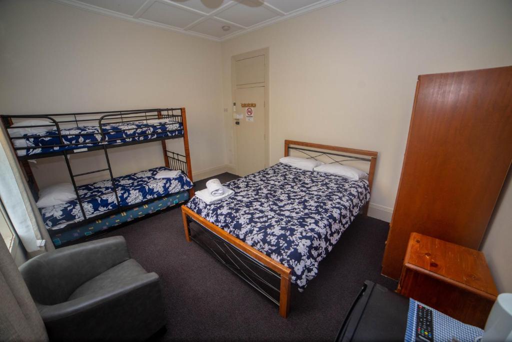 巴利纳澳大利亚酒店的一间小卧室,配有两张双层床和椅子