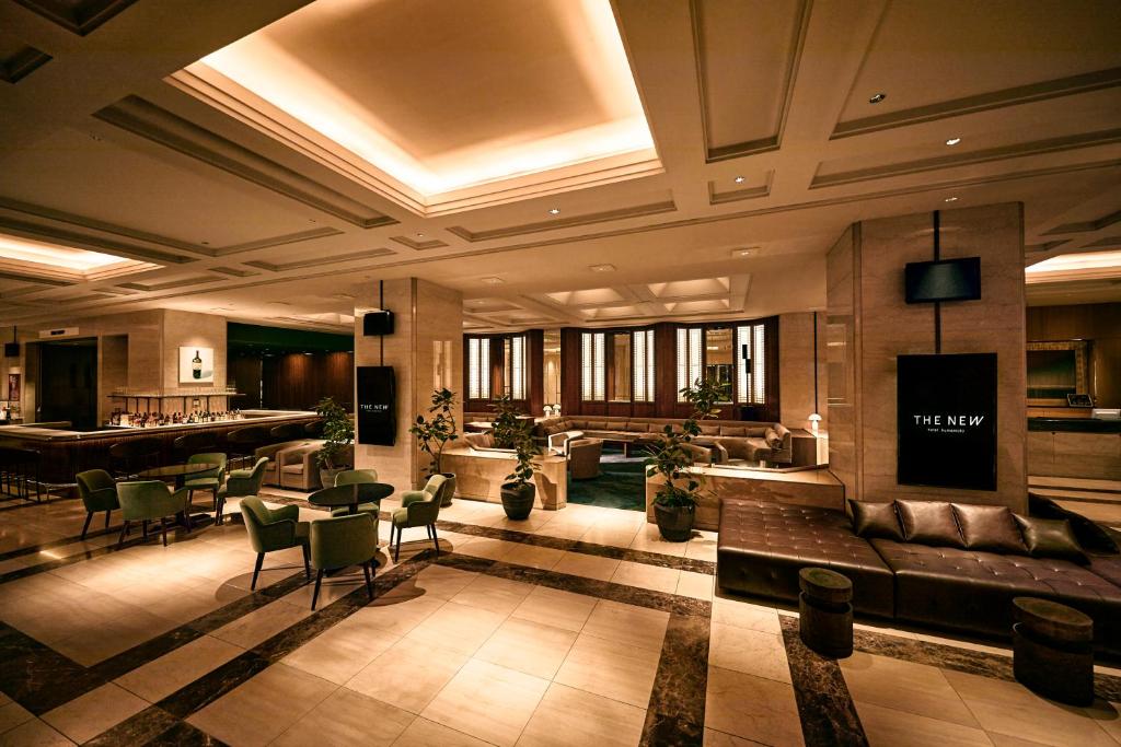 熊本The New Hotel Kumamoto -DLIGHT LIFE & HOTELS-的带沙发和酒吧的大型客厅