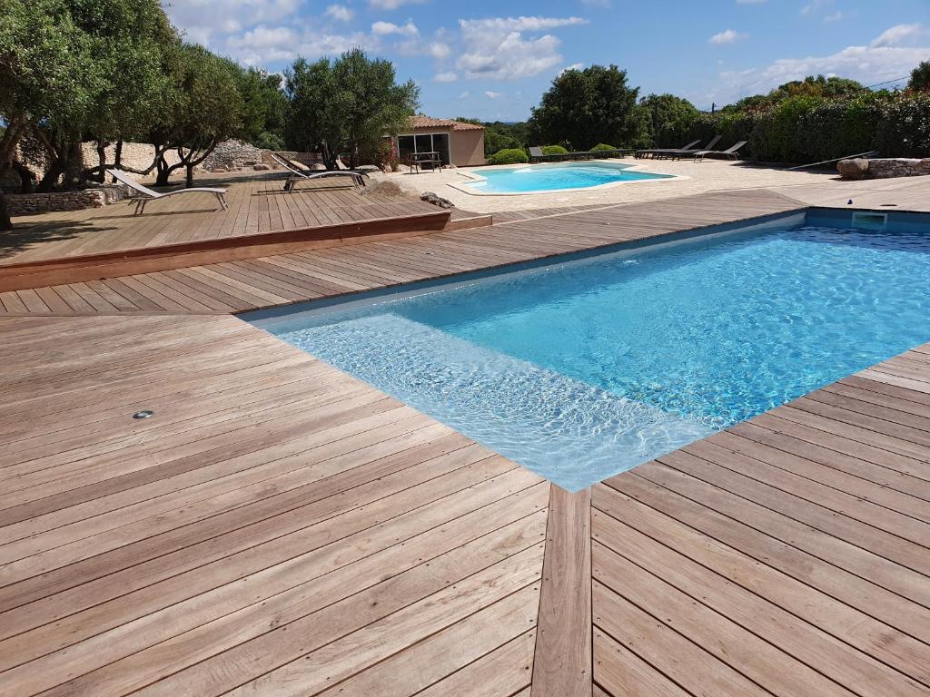 博尼法乔卡纳瓦酒店的一个带木甲板的游泳池和两个游泳池